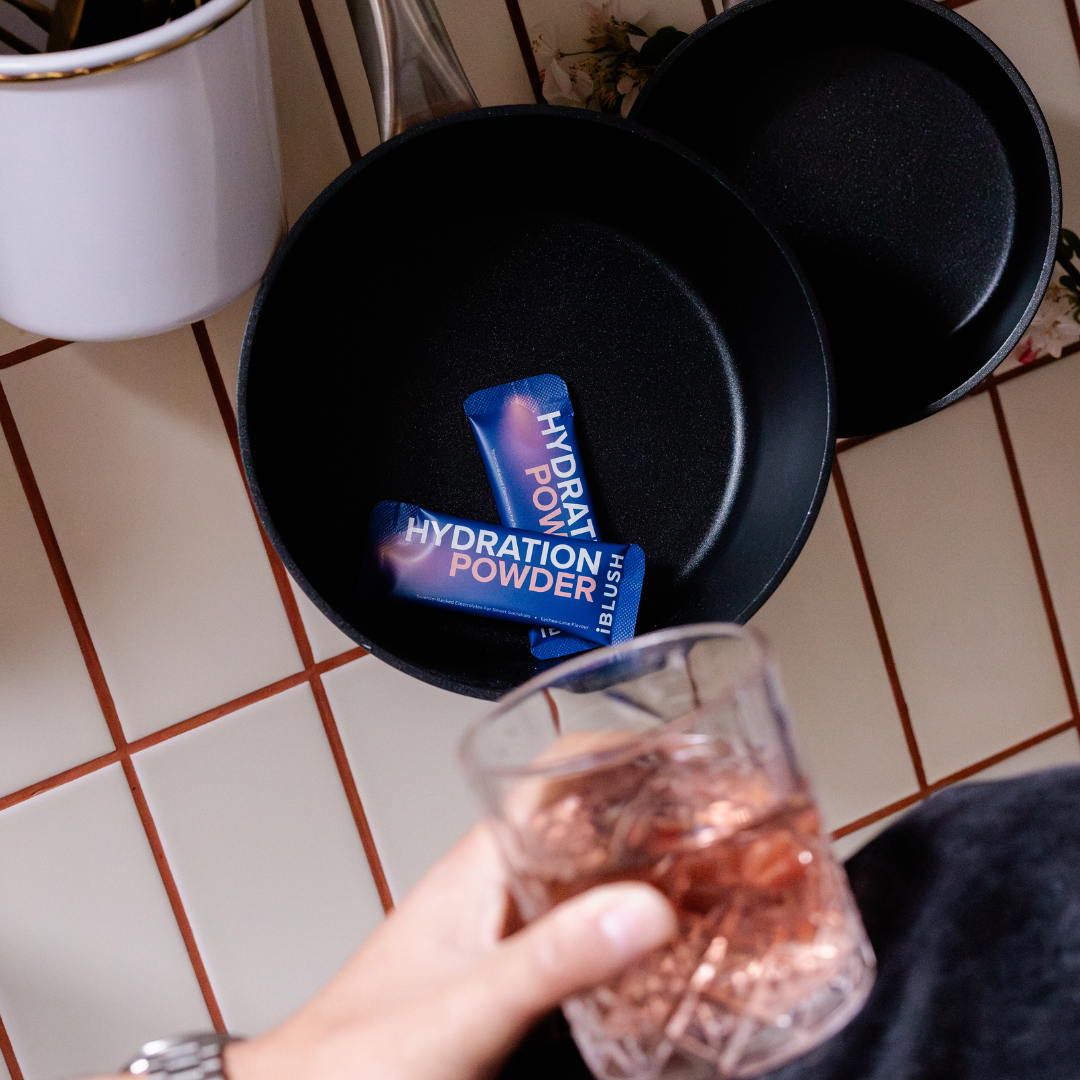 iBlush Hydration Powder electrolyte sachets shown in a lifestyle setting, designed for fast hydration and next-day balance.
