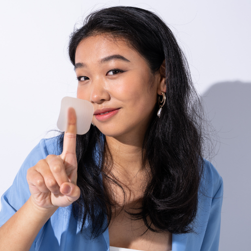 Lydia, founder of iBlush, holding an Asian flush patch to show its texture, alcohol flush patch for Asian glow remedy.